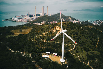 Traditional windmill by sea against sky