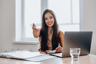 Portrait of woman holding smart phone on table