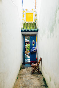 Inside view of a corridor with a lone chair and a single open door