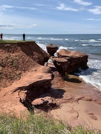 Rock formation on beach against sky