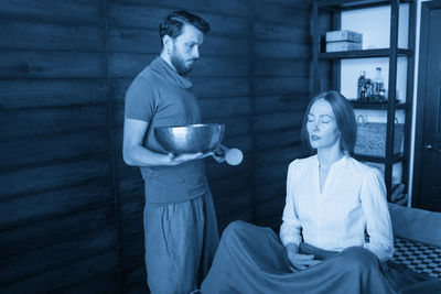 Side view of young woman drinking coffee at home