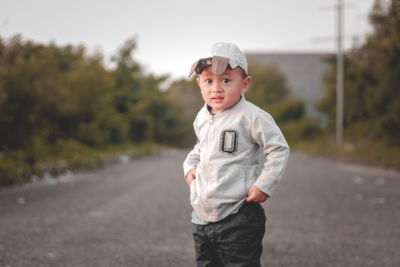 Portrait of young man standing on road