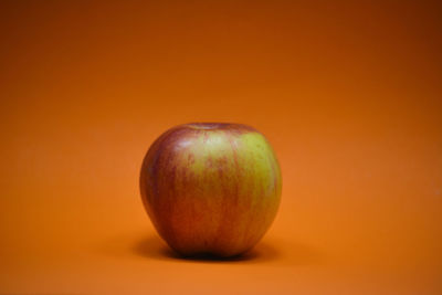 Close-up of apple against orange background