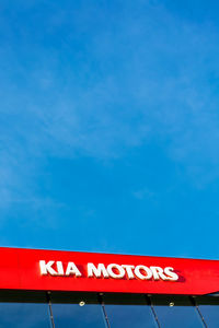 Low angle view of information sign against blue sky