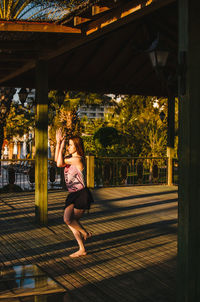 Full length of woman exercising on floor in balcony