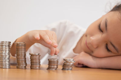 Cropped hand of woman stacking coins on table