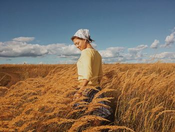 Woman standing on field against sky