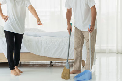 Low section of people standing on bed