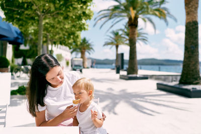Mother and daughter on palm tree