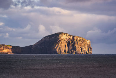 Rock formations in sea against sky