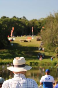 Rear view of man with arms outstretched against plants