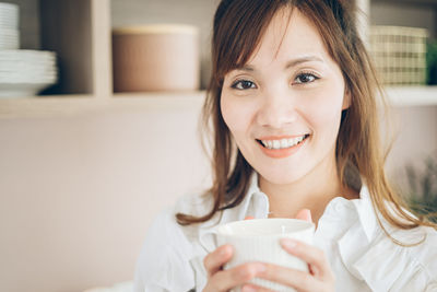 Portrait of smiling woman drinking coffee