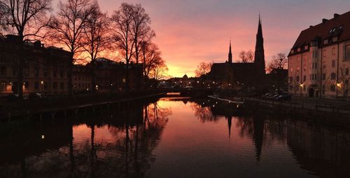 Reflection of buildings in river at sunset