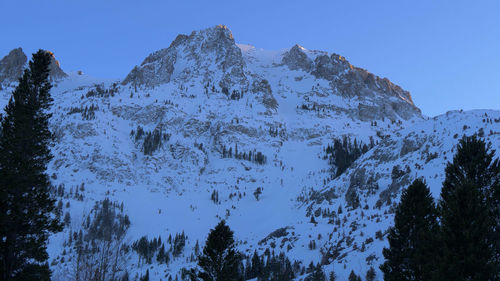 Low angle view of snowcapped mountains against clear sky