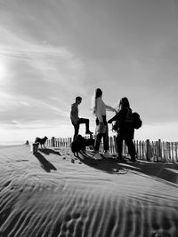 People with dogs standing at beach