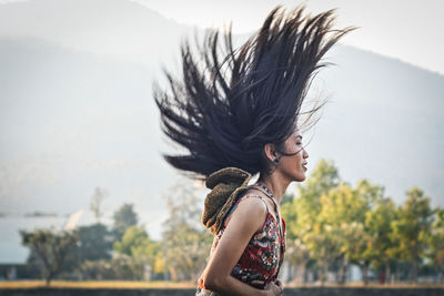 Side view of woman with palm tree