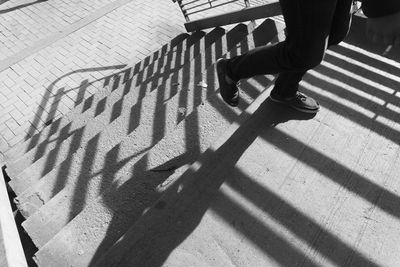 Low section of man walking on footpath in city