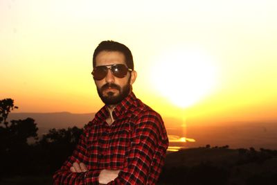 Portrait of young man standing against sky during sunset