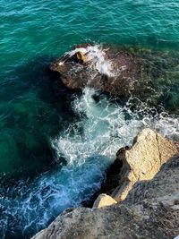 High angle view of waves splashing on rocks