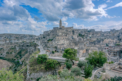 Panoramic view of city buildings against cloudy sky