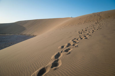 Sand dunes in desert against clear sky