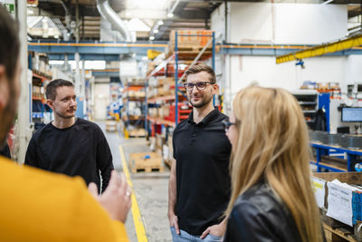 Smiling employee listening to manager in meeting at factory