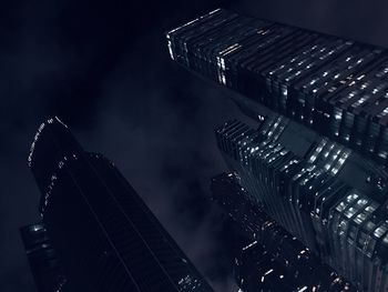 Low angle view of illuminated cityscape against sky at night