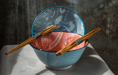 High angle view of paintbrushes in bowl on table