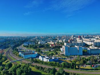 High angle view of buildings in city against blue sky