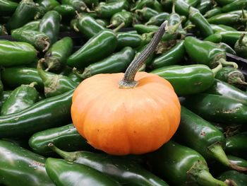 Close-up of pumpkin and green chili peppers for sale at market