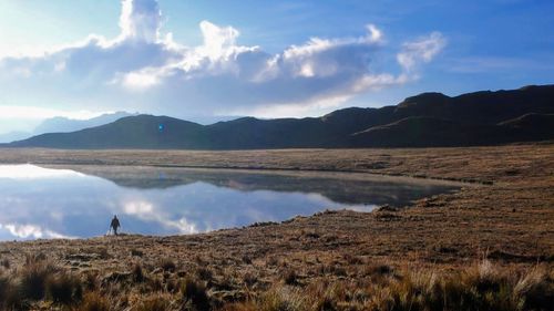 Scenic view of lake by mountains against sky