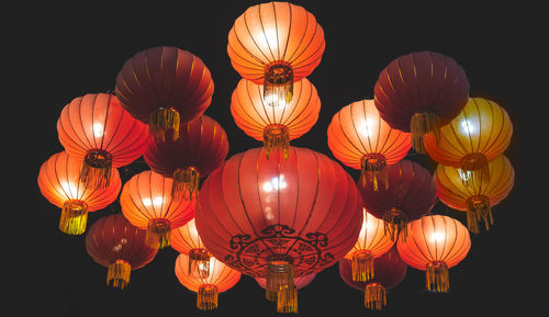 Low angle view of illuminated lanterns hanging at night