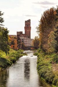 Bridge over river amidst buildings against sky