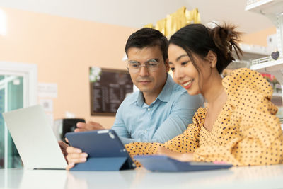 Portrait of woman using laptop while sitting on table