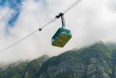 Low angle view of overhead cable car against sky