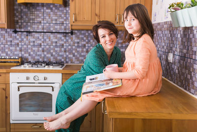 Young woman with daughter standing at home