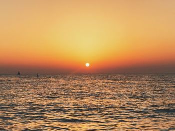 Scenic view of sea against orange sky