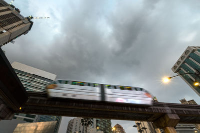 Low angle view of illuminated train against sky in city