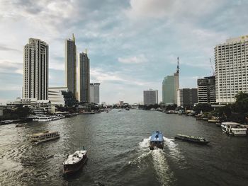 Panoramic view of modern buildings by city against sky