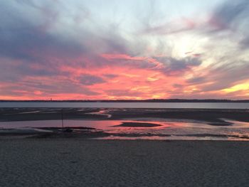 Scenic view of sea against cloudy sky at sunset