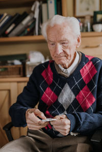 Senior man holding medicine at home