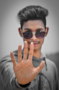 Portrait of man wearing sunglasses gesturing outdoors