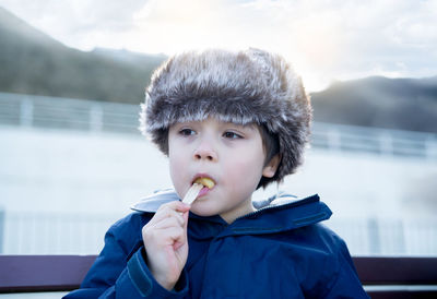 Close-up of boy looking away while eating food outdoors