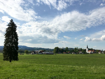 Scenic view of grassy field against cloudy sky