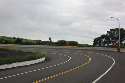 Empty road in city against sky