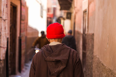 Rear view of man wearing knit hat walking on street in city