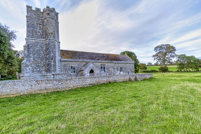 Old ruin building on field against sky