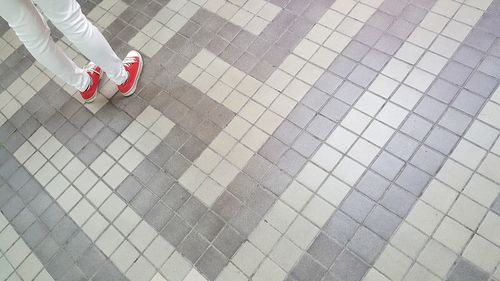 Low section of person standing on tiled floor