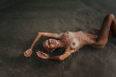 Bald girl in sequins swims in the sea