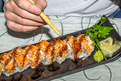 Midsection of man having sushi on table